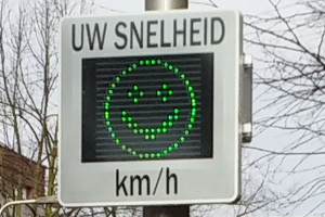 Een snelheidsbord met een groene smiley erop. 