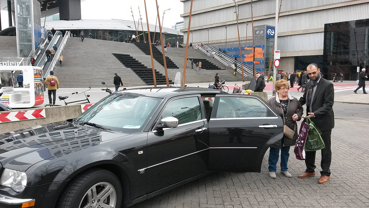 Taxichauffeur laat oude dame uitstappen op het Stadspaleau te Utrecht