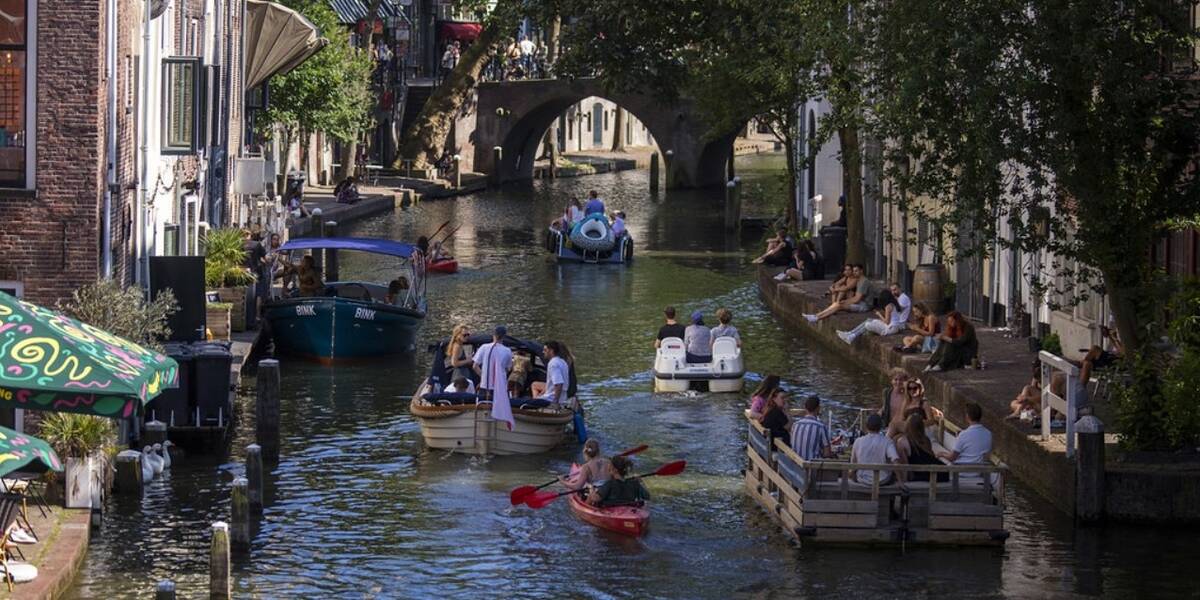 Link naar foto in Flickr: mensen varen door de oudegracht met kano's en bootjes.