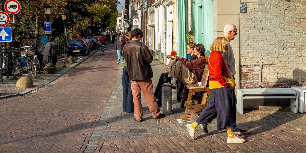 Link naar foto in Flickr: mensen lopen en zitten boven bij de Oudgracht.