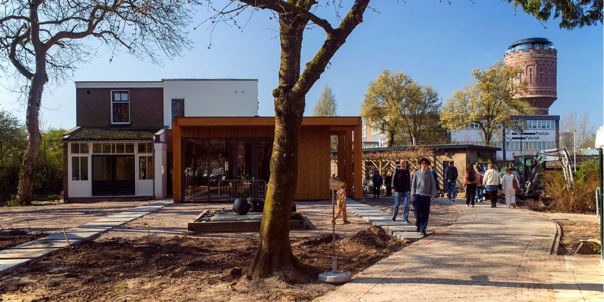 Link naar foto in Flickr: mensen komen kijken bij de Renovatie kinderboerderij Rotsoord, op de achtergrond de watertoren.