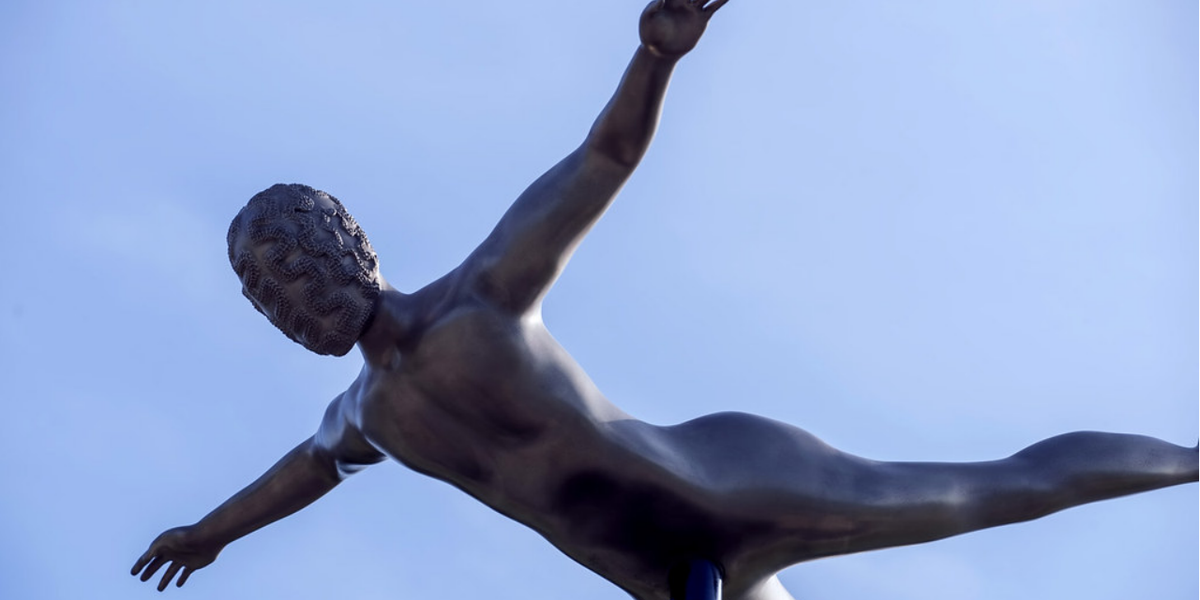 Link naar Flickr: slavernijverleden monument onderaanzicht met op de achtergrond blauwe lucht.