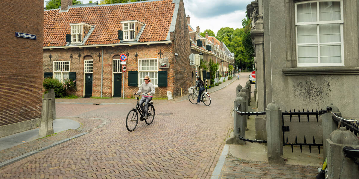 Link naar foto in Flickr: twee fietsers op de kruising bij de stoplichten in de Agnietenstraat