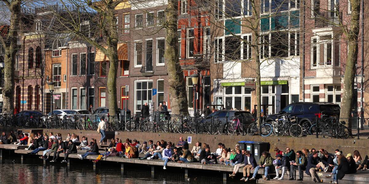 Link naar foto in Flickr: mensen zitten in de zon op de kade van de Bemuurde Weerd.