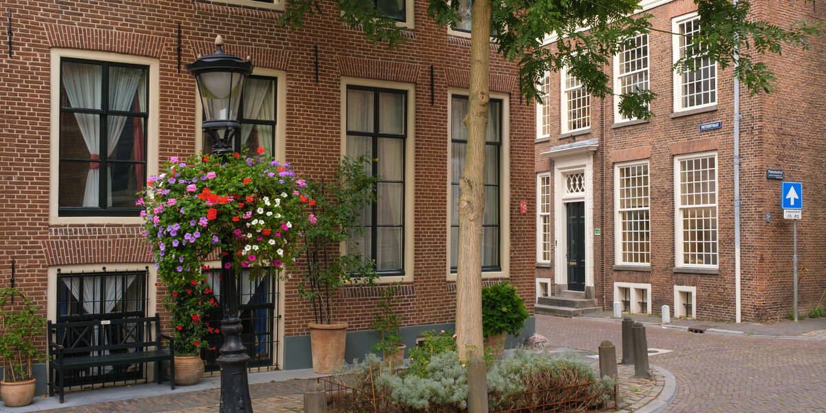 Link naar foto in Flickr: bloemen aan de lantaarnpaal bij huizen aan de Pieterskerkhof.
