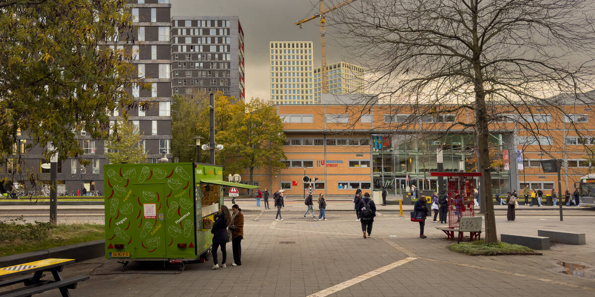 Link naar foto in Flickr: studenten bij de Heidelberglaan, op de voorgrond een eetkraam op de achtergrond een gebouw van de hogeschool van Utrecht.