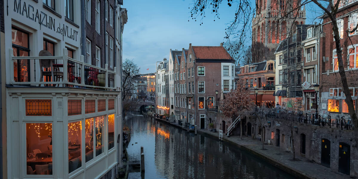 Link naar foto in Flickr: Oudegracht met de achterkant van de Lijnmarkt met de aanduiding Magazijn de Vlijt nog op de achtergevel. Op de achtergrond de café's van de Donkere Gaard en de verlichte Domtoren.