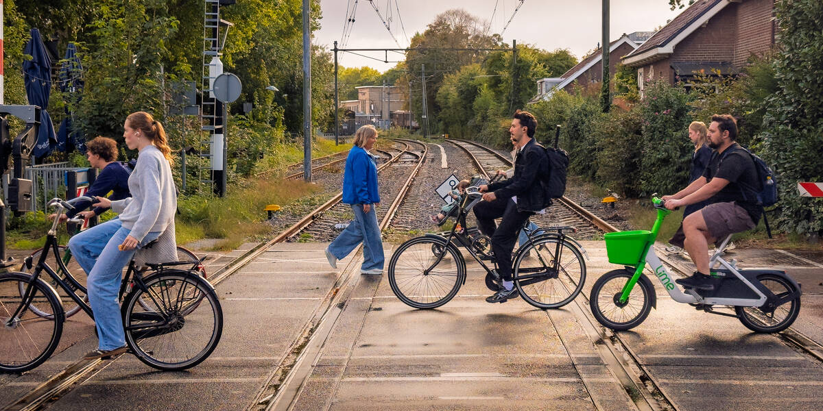 Link naar foto in Flikcr: Fietsers en wandelaar gaan over de Spoorwegovergang Burgemeester Reigerstraat. Met op de achtergrond het Spoorwegmuseum.