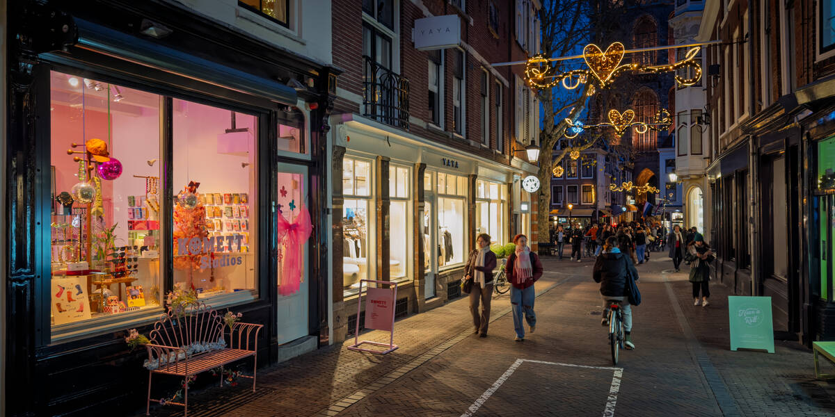 Link naar foto in Flickr: winkelend publiek loopt door een sfeerverlichte Zadelstraat.