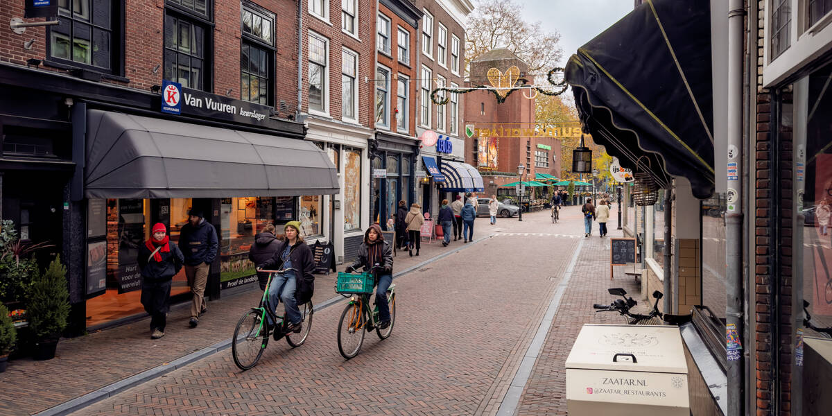 Link naar foto in Flickr: 2 fietsers gaan door de Twijnstraat. Op de achtergrond Ledig Erf.