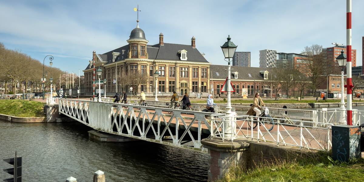 Link naar foto in Flickr: fietsers gaan over de Muntbrug, met op de achtergrond het Muntgebouw.