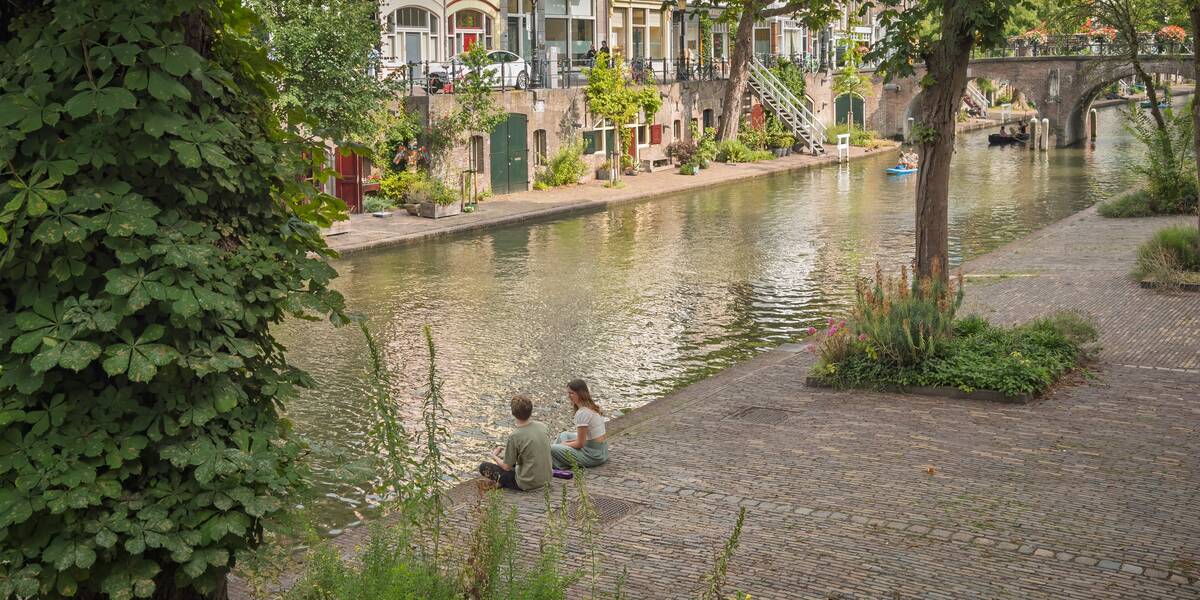 Link naar foto in Flickr: 2 mensen zitten aan de gracht. 
