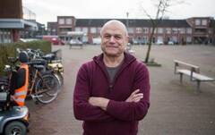 Een man op de voorgrond, voor een pleintje met fietsen op de achtergrond