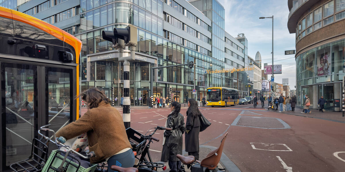 Link naar foto in Flickr: mensen staan bij het stoplicht bij de Lange Viestraat. Van beide kanten komt er een bus aan.
