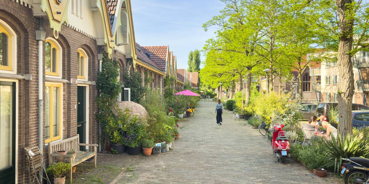 Link naar foto in Flickr: mensen zitten in de zon in de Veeartsenijstraat.