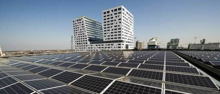 Zonnepanelen met het stadskantoor op de achtergrond