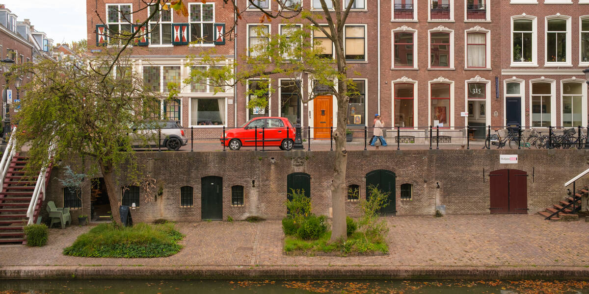 Link naar foto in Flickr: Zicht op de werf en de Oudegracht met bovenaan de gracht een rode auto.