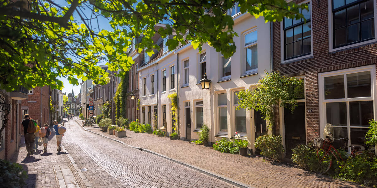Link naar foto in Flickr: mensen lopen door een zonnige Vrouwjuttenstraat.
