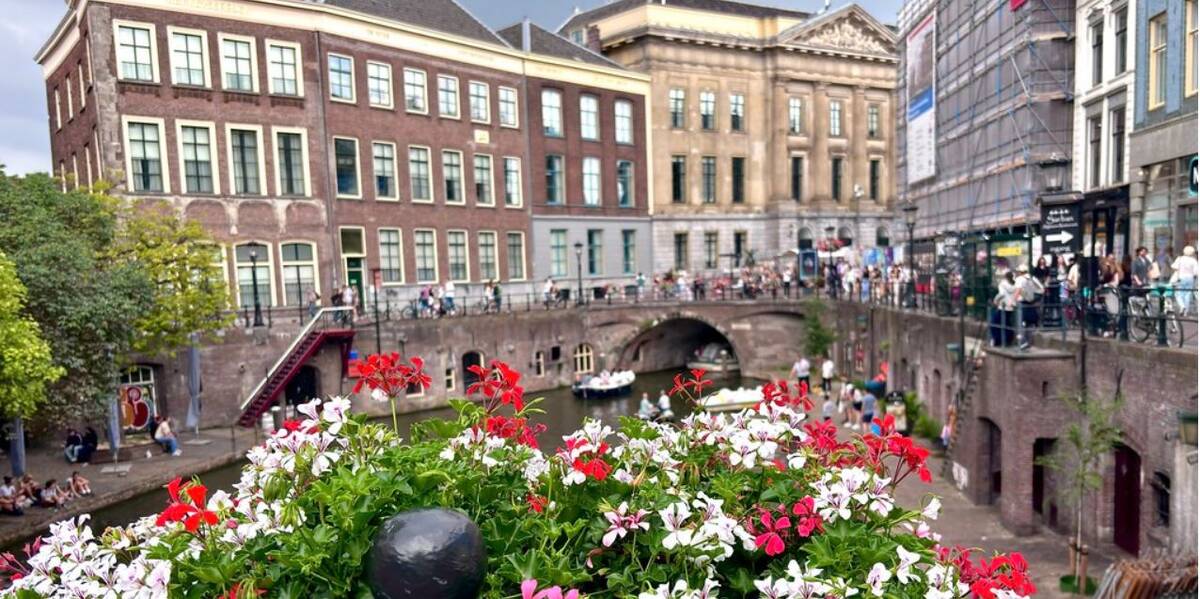 Link naar foto in Flickr: bloemen aan de brug bij de Oudegracht. Op de achtergrond het stadhuis.