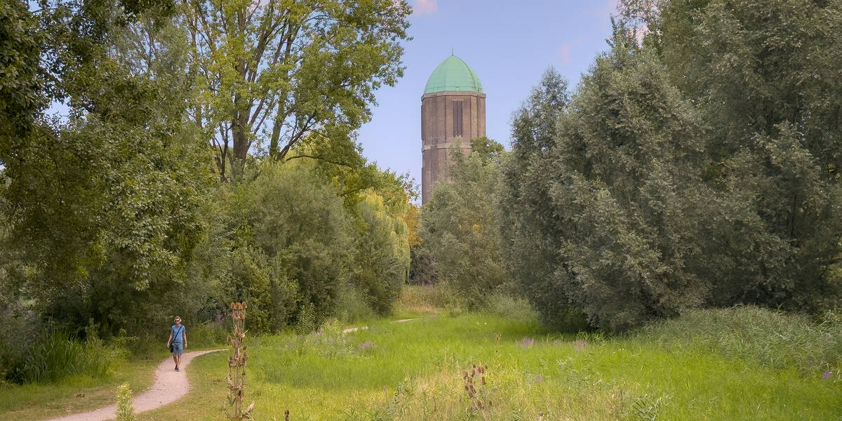Link naar foto in Flickr: Op de achtergrond de watertoren van Overvecht. Op de voorgrond een wandelaar. 