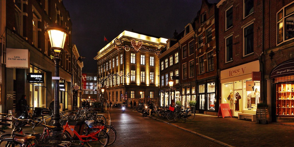 Link naar foto in Flickr: de straat Oudkerkhof bij avondlicht, op de achtergrond het stadhuis in verlichting.