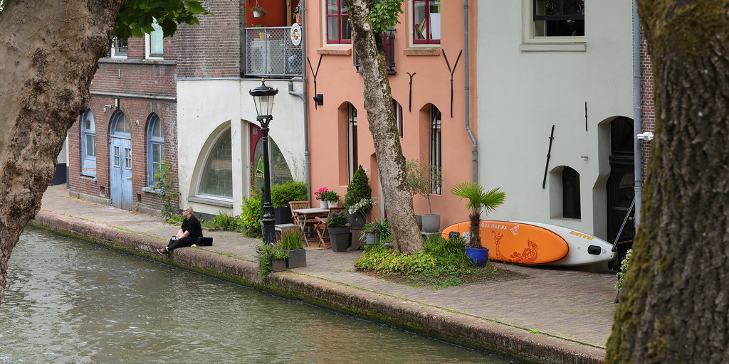 Link naar foto in Flickr: een man zit aan de gracht bij Twijnstraat aan de Werf.