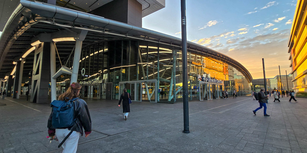 Link naar foto in Flickr: mensen lopen bij zonsopkomst richting het centraal station.