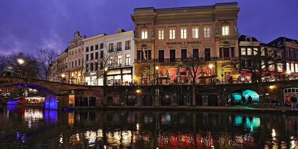 Link naar foto in Flickr: zicht op de Winkel van Sinkel bij avondlicht.