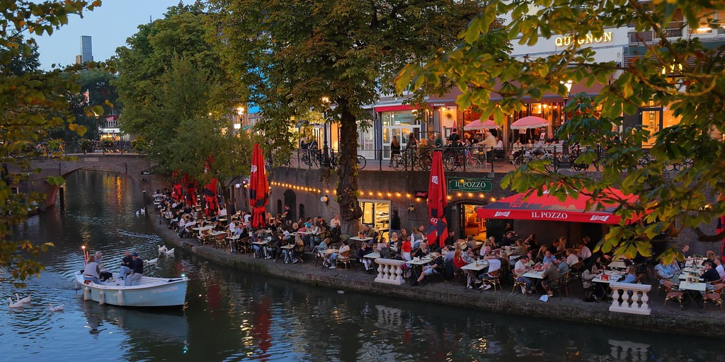 Link naar foto in Flickr: mensen zittten in de avond op het terras aan de Oudegracht.