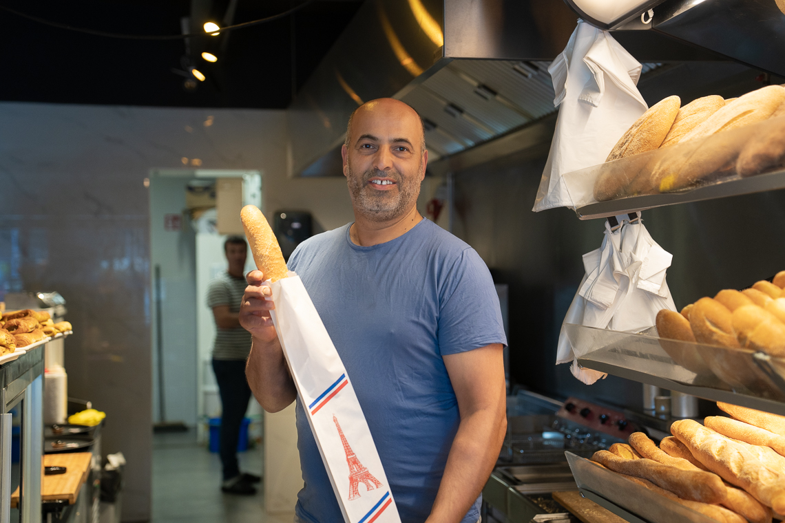 Mohamed el Haddad Assoufi in zijn bakkerij met stokbrood in zijn hand