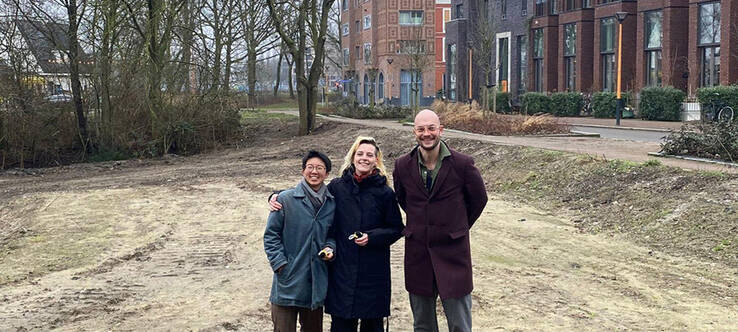 bouwgroepleden li-an en sam van hommeldorp samen met wethouder de vries op de bouwkavel